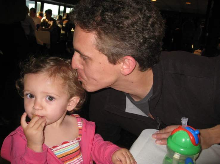 a man licking a small girl's lips with her finger