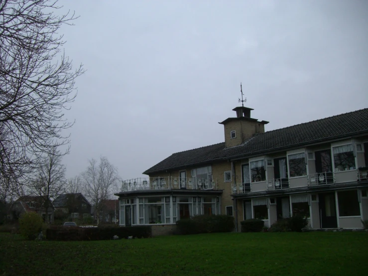 two story house on the lawn facing away from a tree