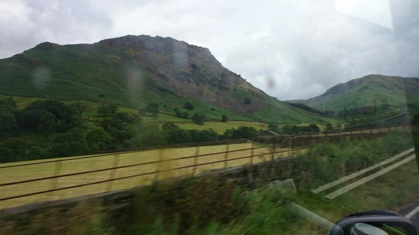 a road going through green mountains and grass