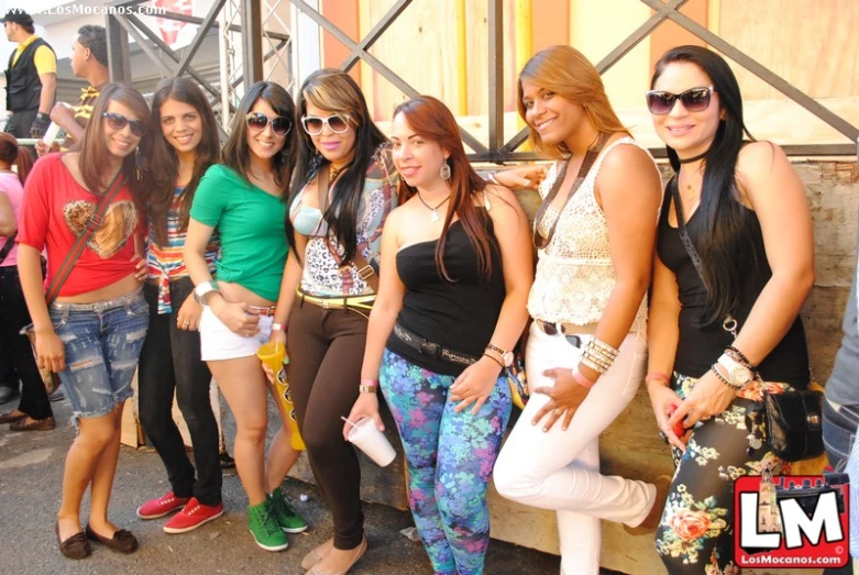 several beautiful women posing for a po in front of a bar