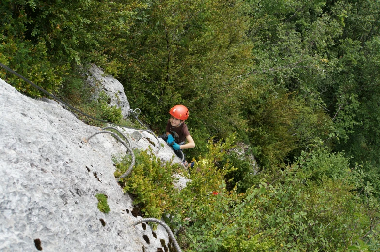 a man climbs up a steep cliff on a hike