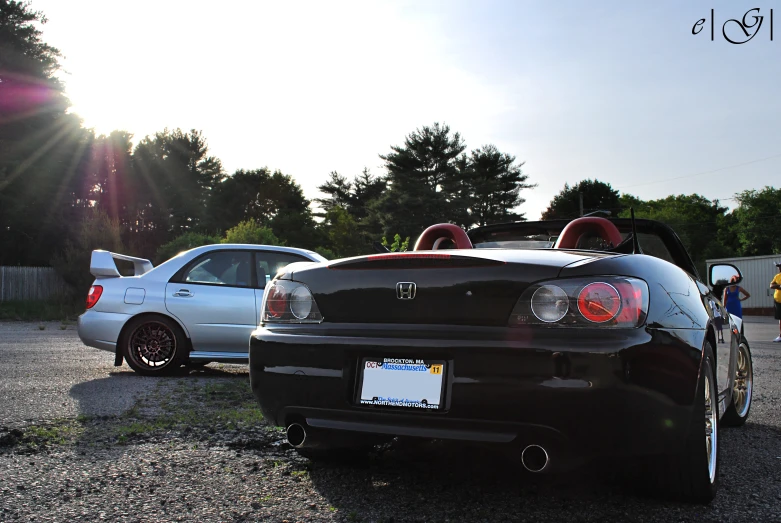 two cars parked in a parking lot with trees