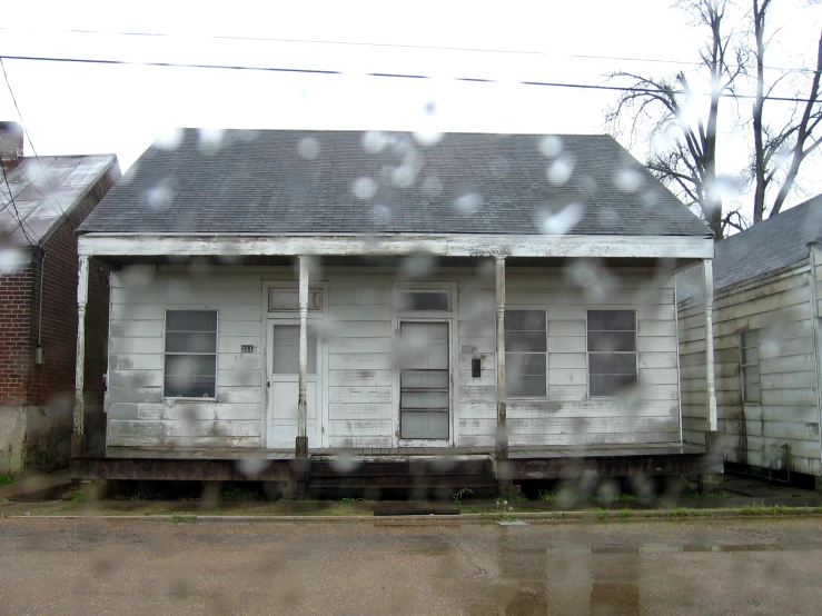 the front of an old house is seen through a window