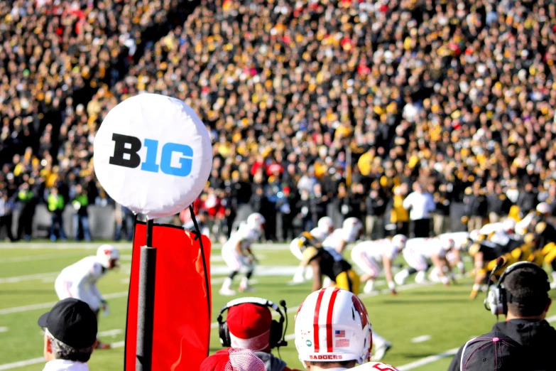 people are watching a football game from the sideline