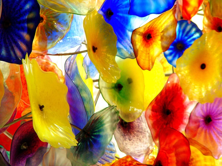 several different colored glass flowers in a window