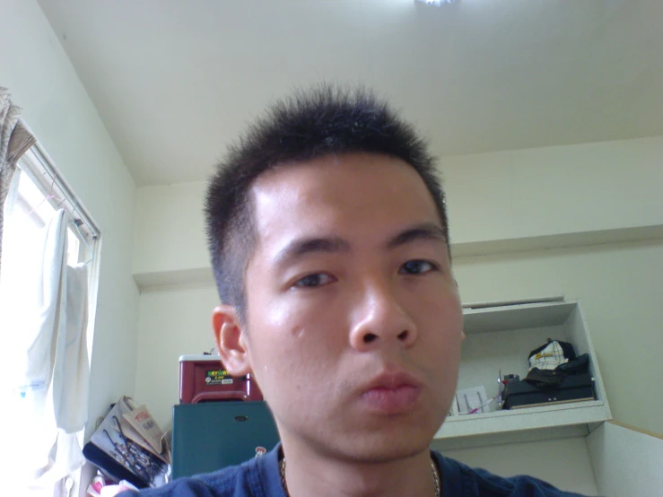 an asian man with short hair looks surprised