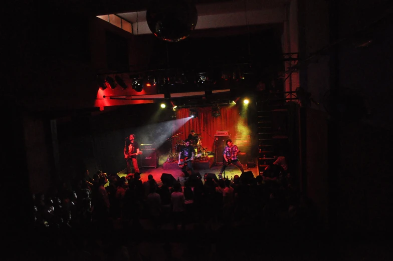 a crowd is standing under the stage and lighting up