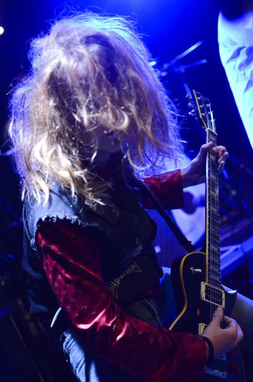 a woman playing a guitar on a stage