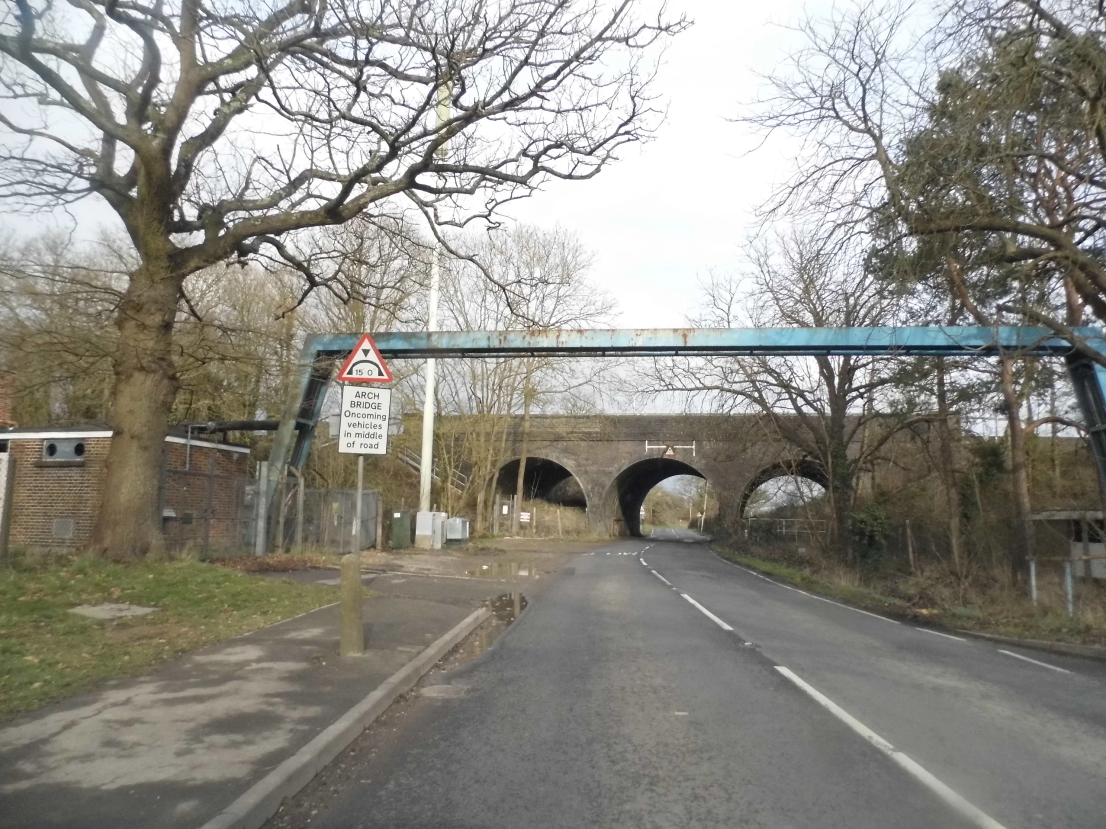 a bridge with a sign that reads it is over an empty road