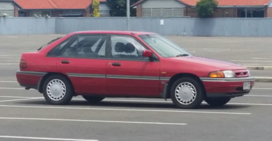 a red car is parked in a parking lot