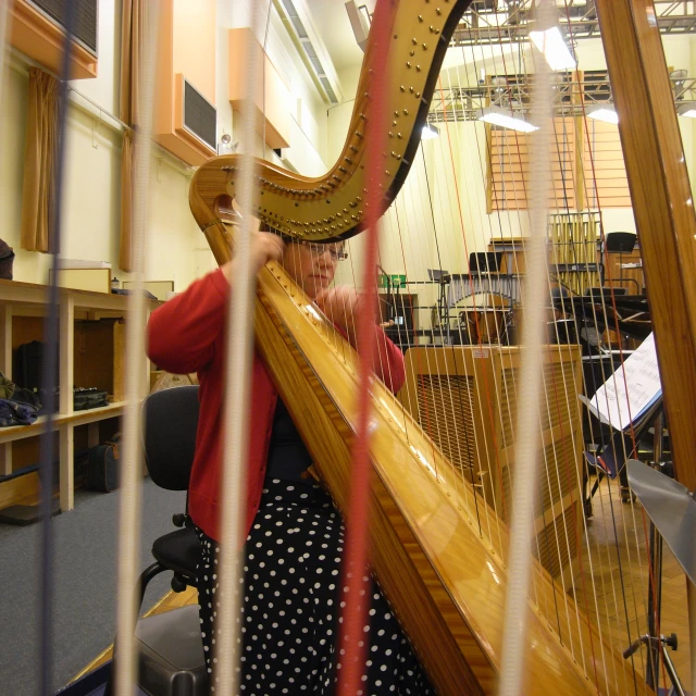 a woman holding a harp while sitting at a desk