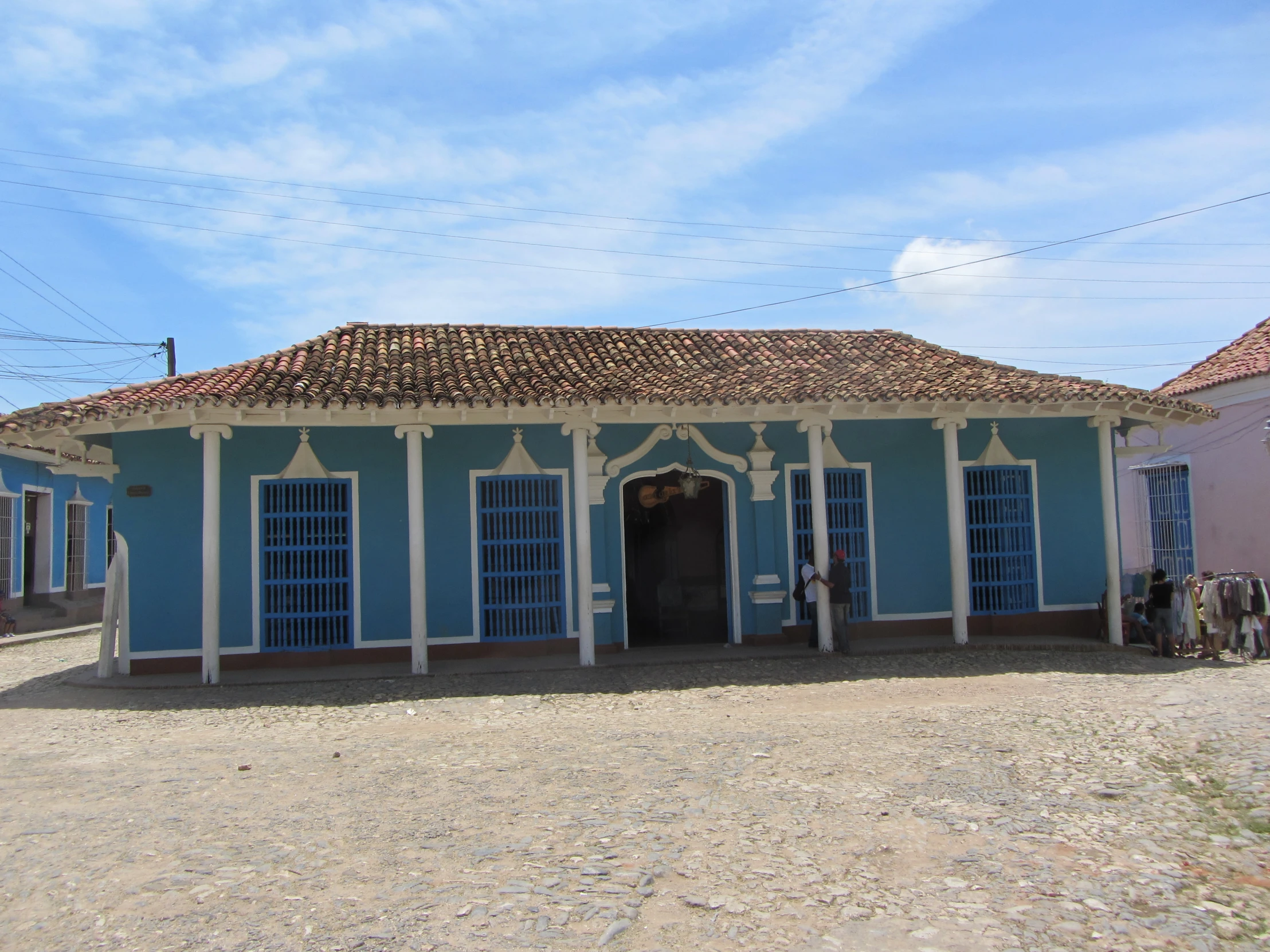 a white and blue building next to two pink buildings