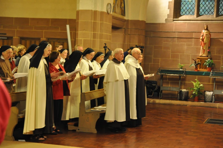 a group of priests holding out their hands at the alter