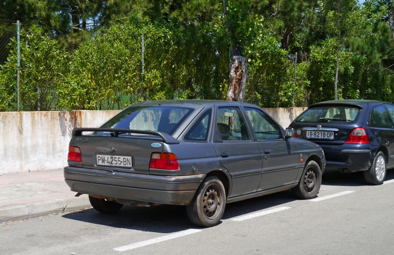 two cars are parked on the side of the road