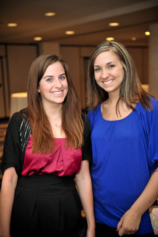 two women are posing for the camera near a mirror