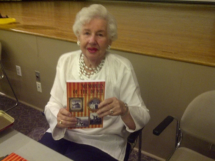 an older woman holding a book about science