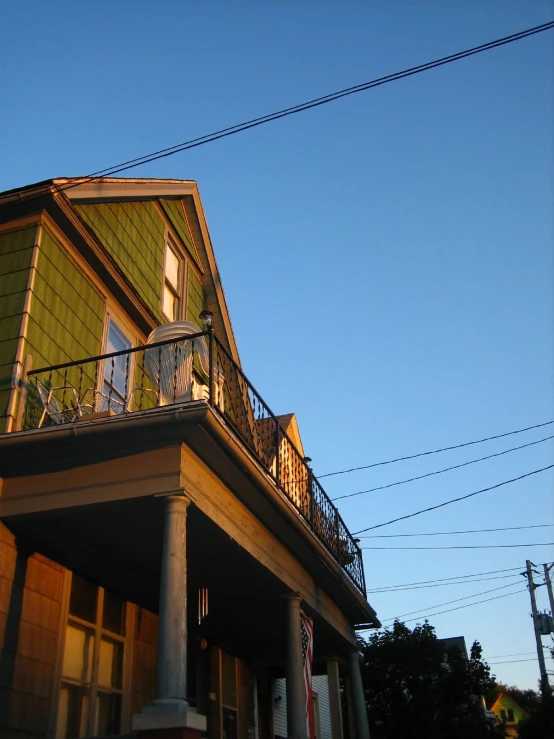 an elegant home sits tall and has a second story balcony