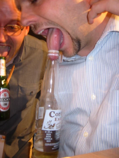 a man sticking his tongue out inside of a glass bottle