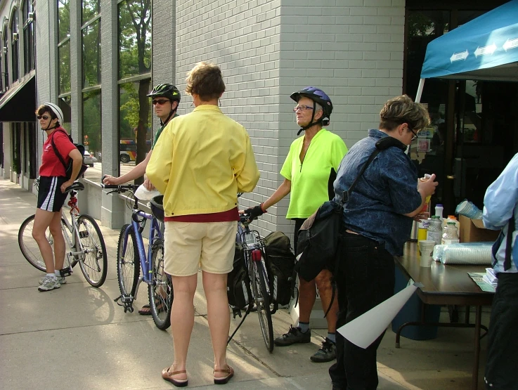 people standing in line near bikes on sidewalk