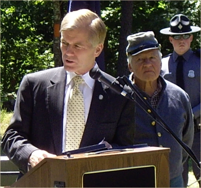 a man standing at a podium next to a microphone