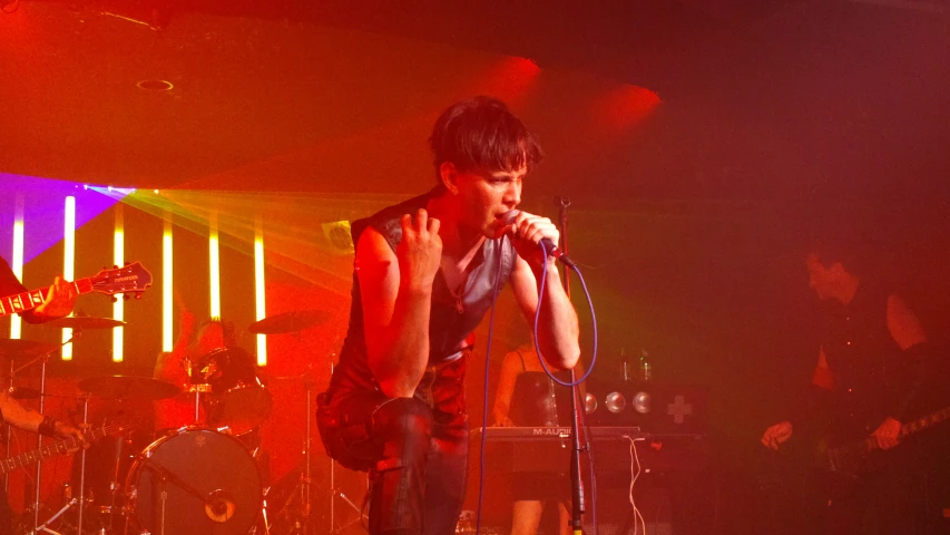 the young man stands on the stage singing