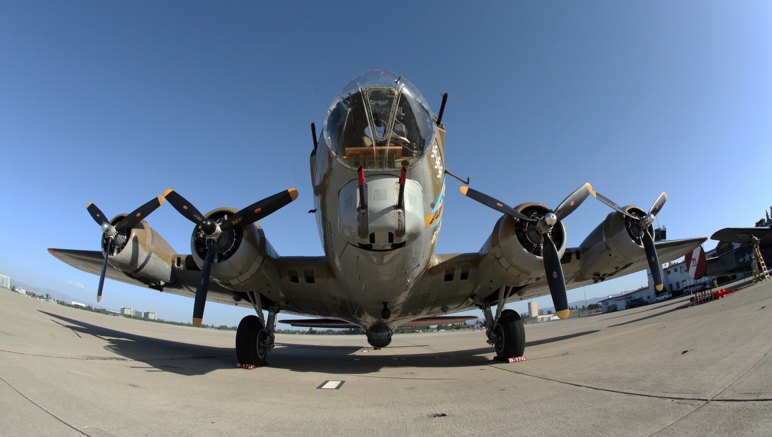 a old plane sits on the tarmac on a sunny day