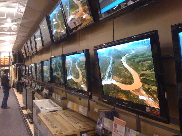 multiple flat screen televisions hung on a wall