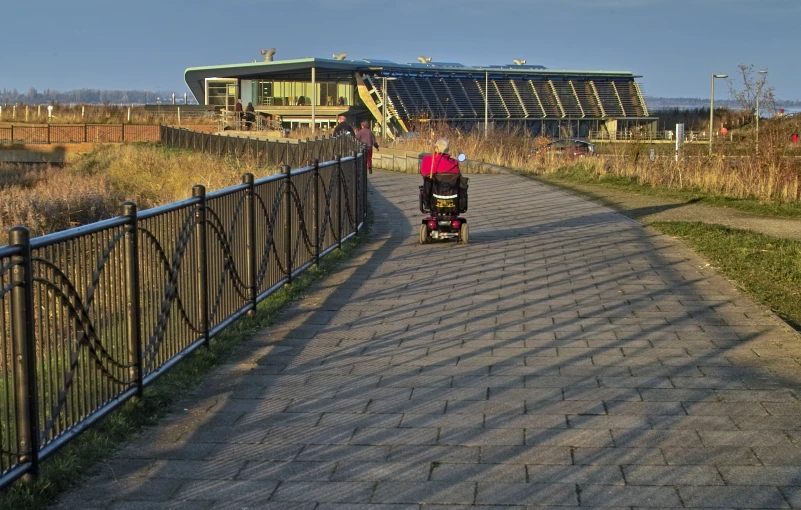 a woman riding on a scooter across a bridge