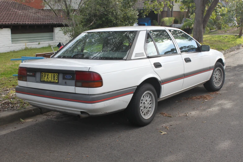 the car parked next to the street has its license plate