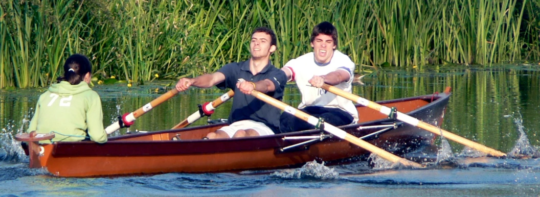 two men are rowing together on a small boat