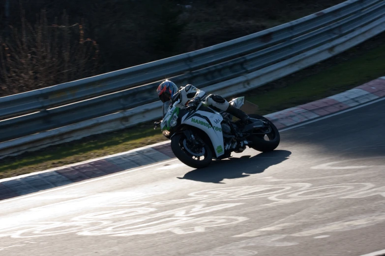 a motorcycle going down a winding street on the side of the road