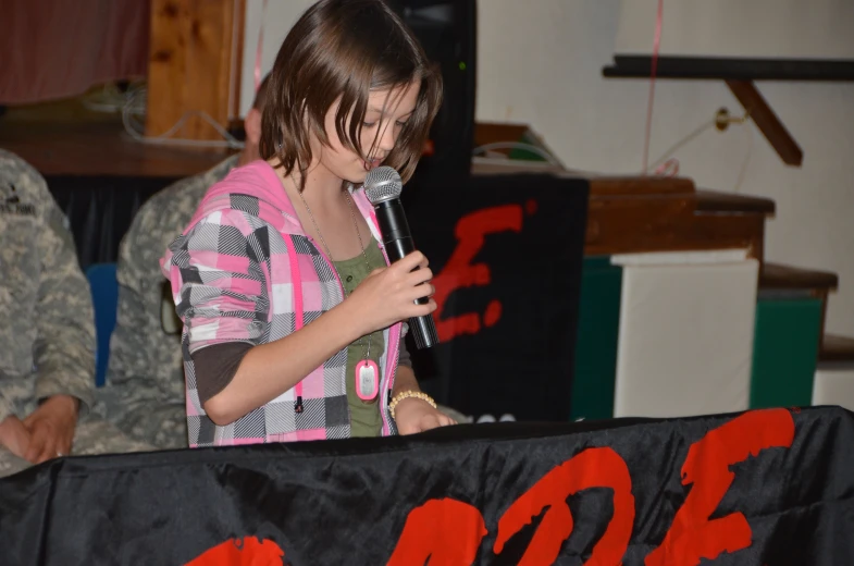 the girl is holding a microphone at a public event