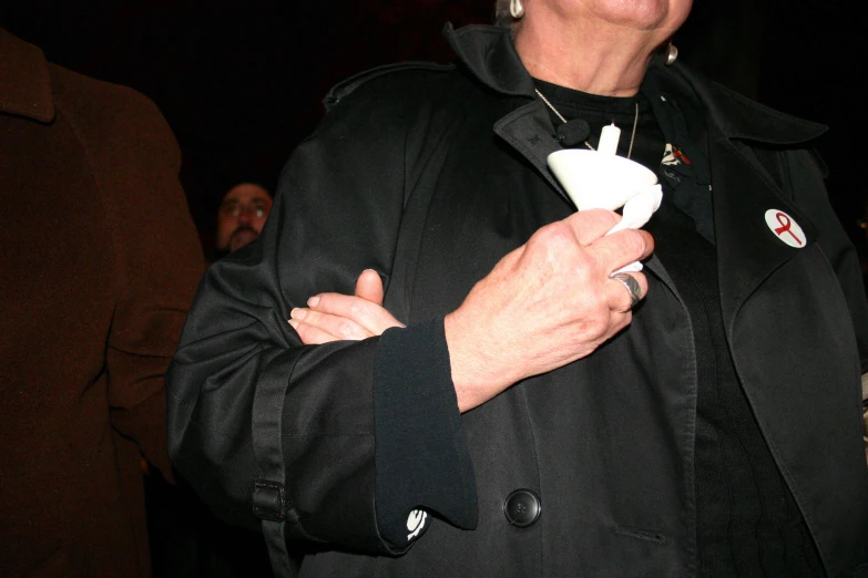 a woman in a black coat holding a wii controller