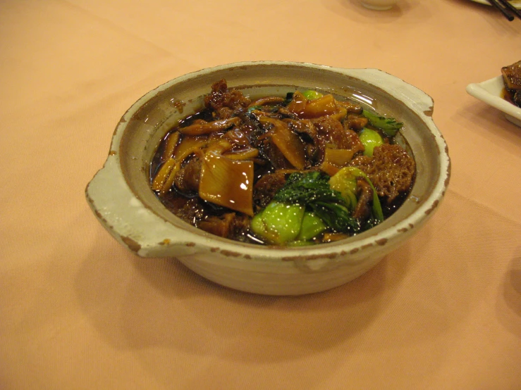 a bowl filled with stir fry vegetables on top of a table
