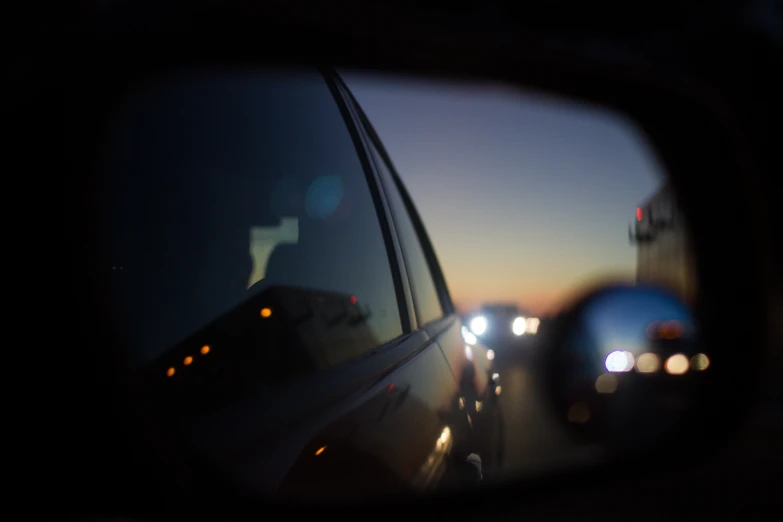 rear view mirror with the reflection of cars parked