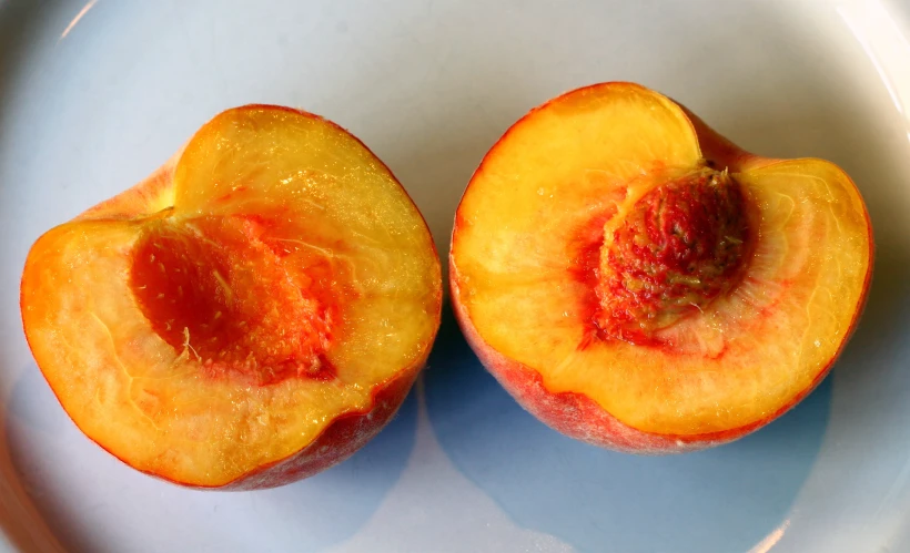 a close up of two peach halves on a plate
