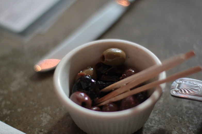 asian chopsticks and black olives in small white bowl