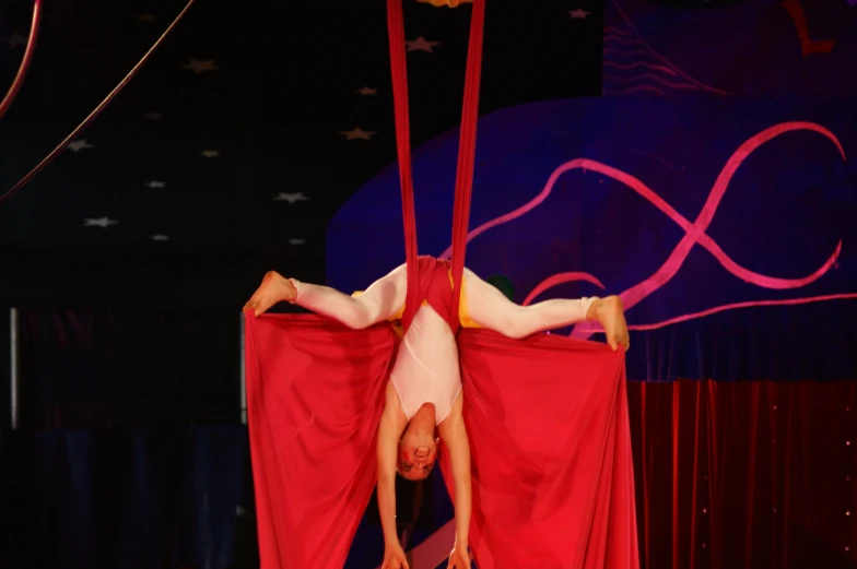 a woman on top of the pole is doing tricks