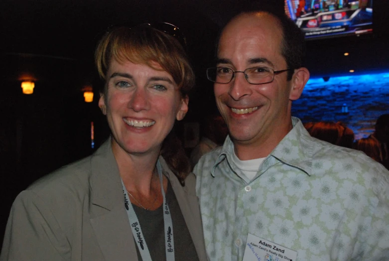 two people smile while standing at an event