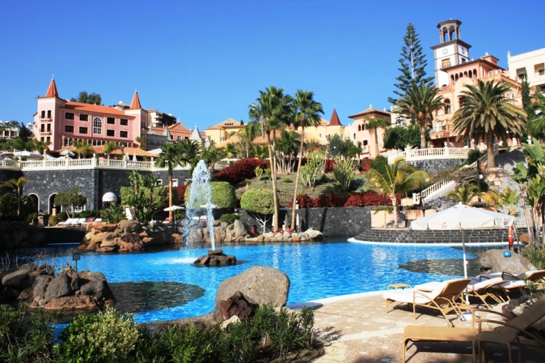 a resort pool with lounge chairs around it