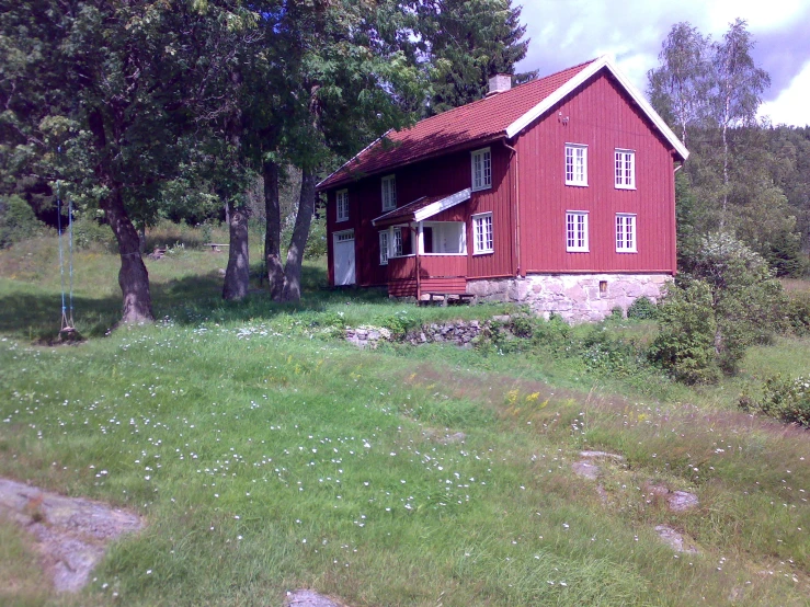 a red house sits on the side of a hill