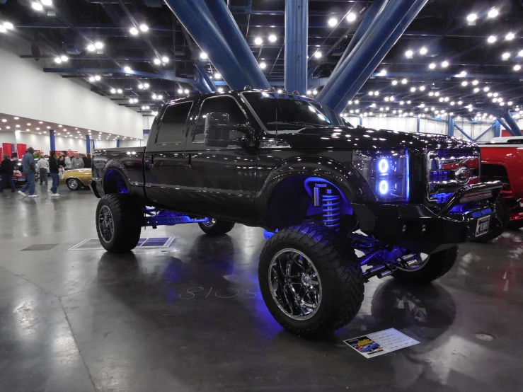 an all black truck parked in a big room