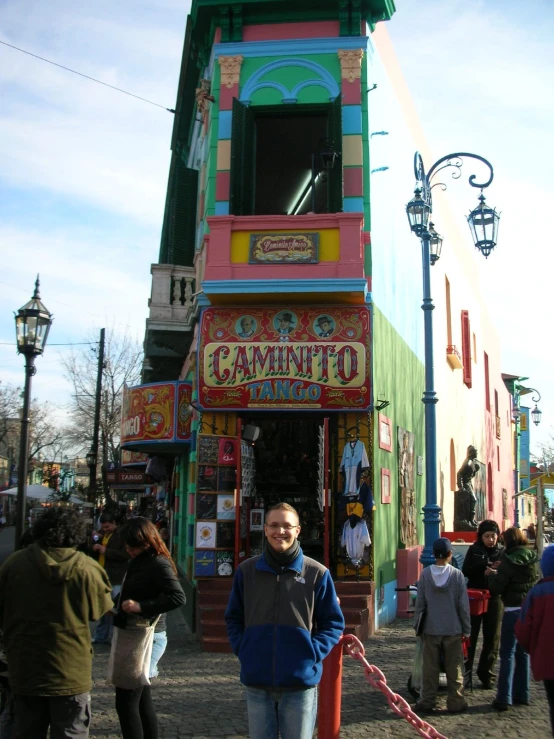 a man is standing outside a brightly painted store