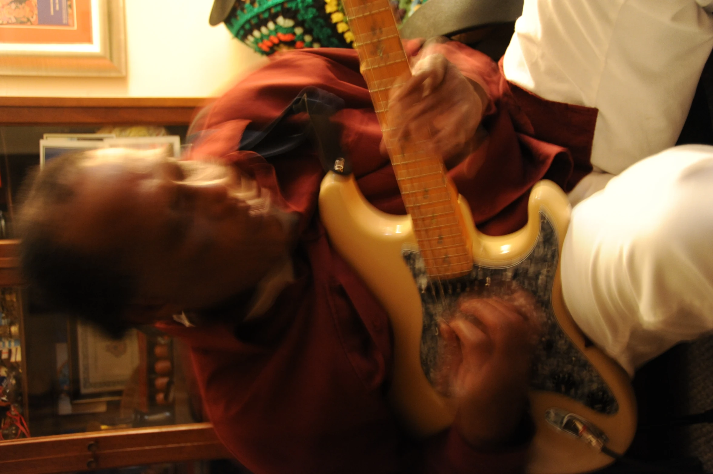 the man is playing a yellow guitar in his living room