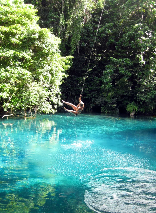 a person swinging off the side of a rope