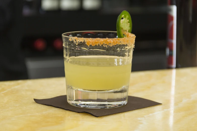 an alcoholic drink in a glass on top of a table