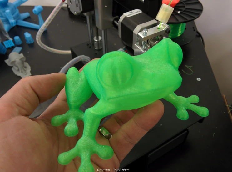 a small green frog that is made of some plastic