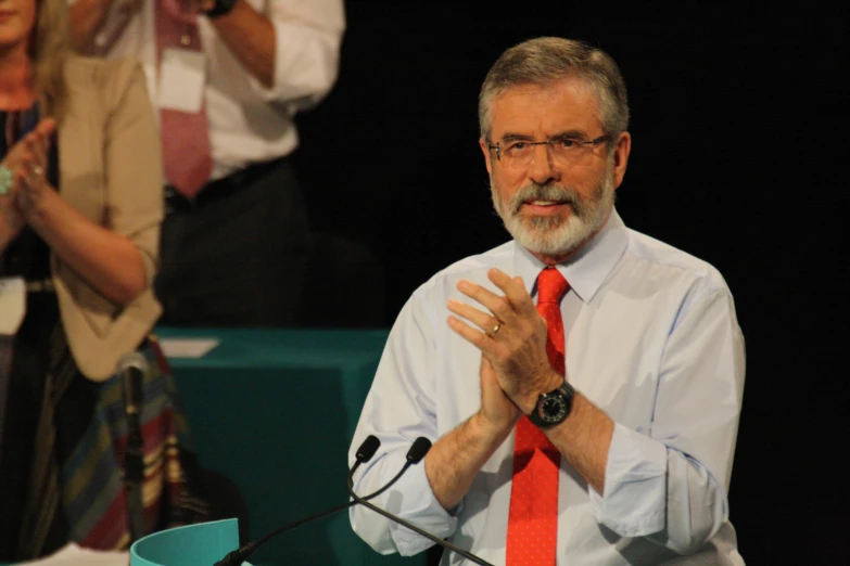 a man wearing a tie speaking on a stage