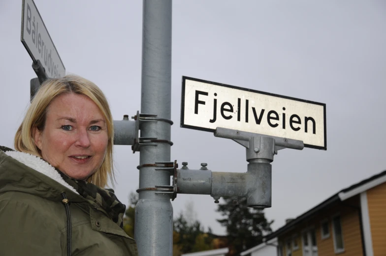 a woman standing next to a street sign