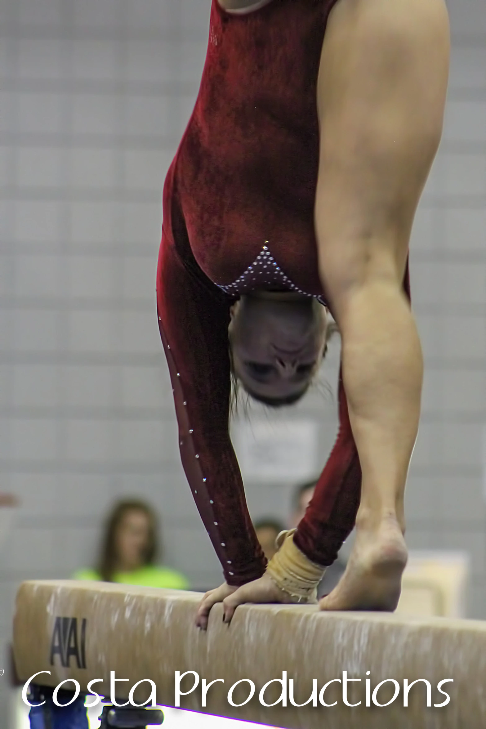 a woman performs on the balance bars at a gymnastics competition